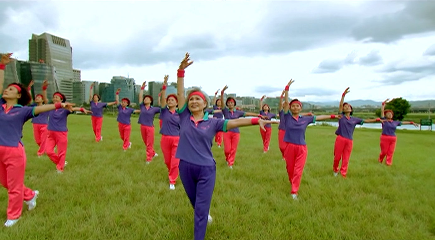 Praise Dance group moving together outdoors on a green field